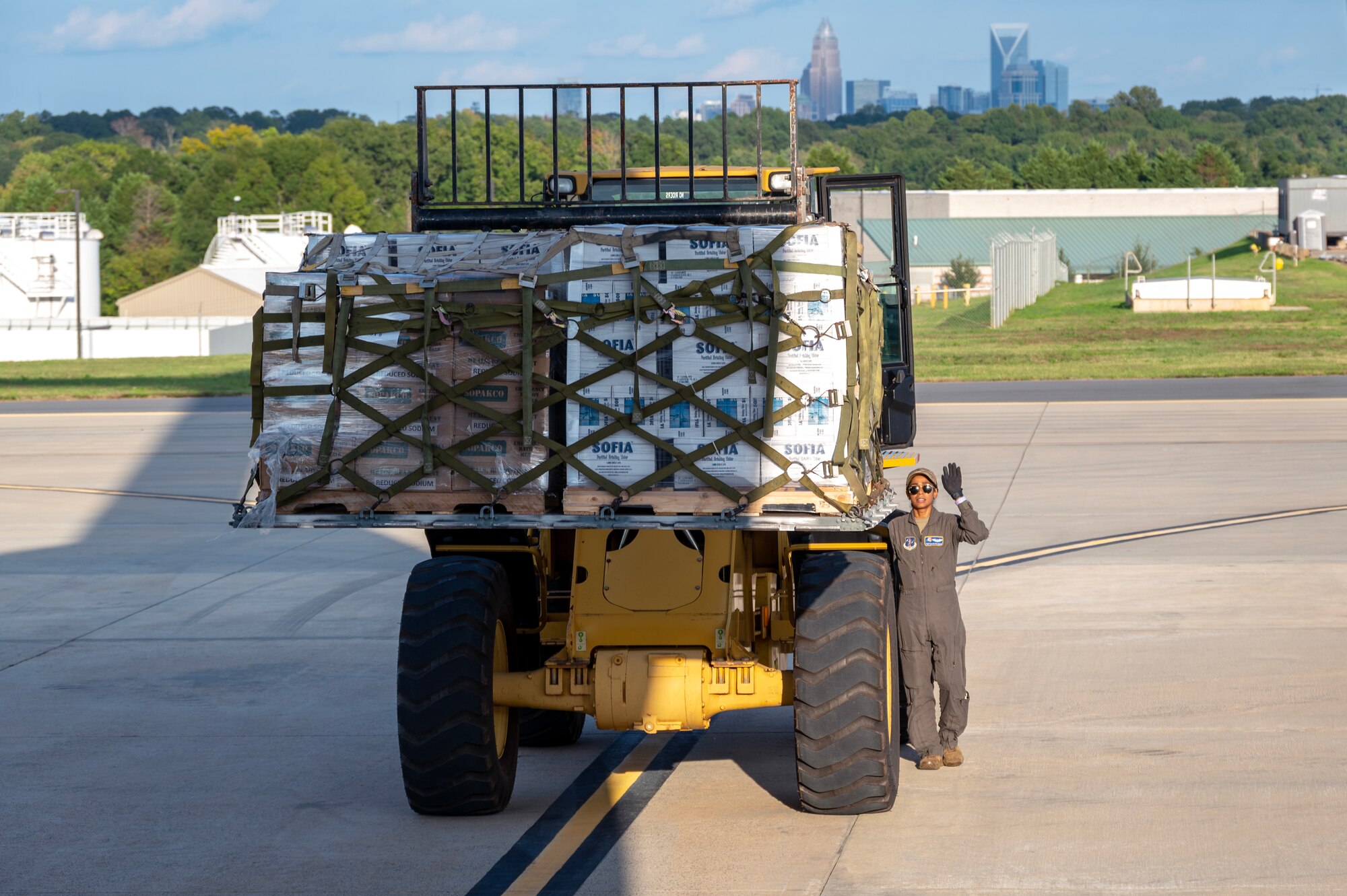 Tech. Sgt. Kaushika P. Silva, 156th Airlift Squadron loadmaster, marshals an all-terrain forklift carrying a hurricane relief pallet to a C-17 Globemaster III for delivery to Western North Carolina in support of humanitarian efforts following Tropical Storm Helene at the North Carolina Air National Guard, Charlotte-Douglas International Airport, October 3, 2024. The cargo delivered aboard the C-17 consisted of Meals Ready to Eat (MREs), water, medication and other vital supplies.  (U.S. Air National Guard photo by Staff Sgt. Reanna Hartgrove)