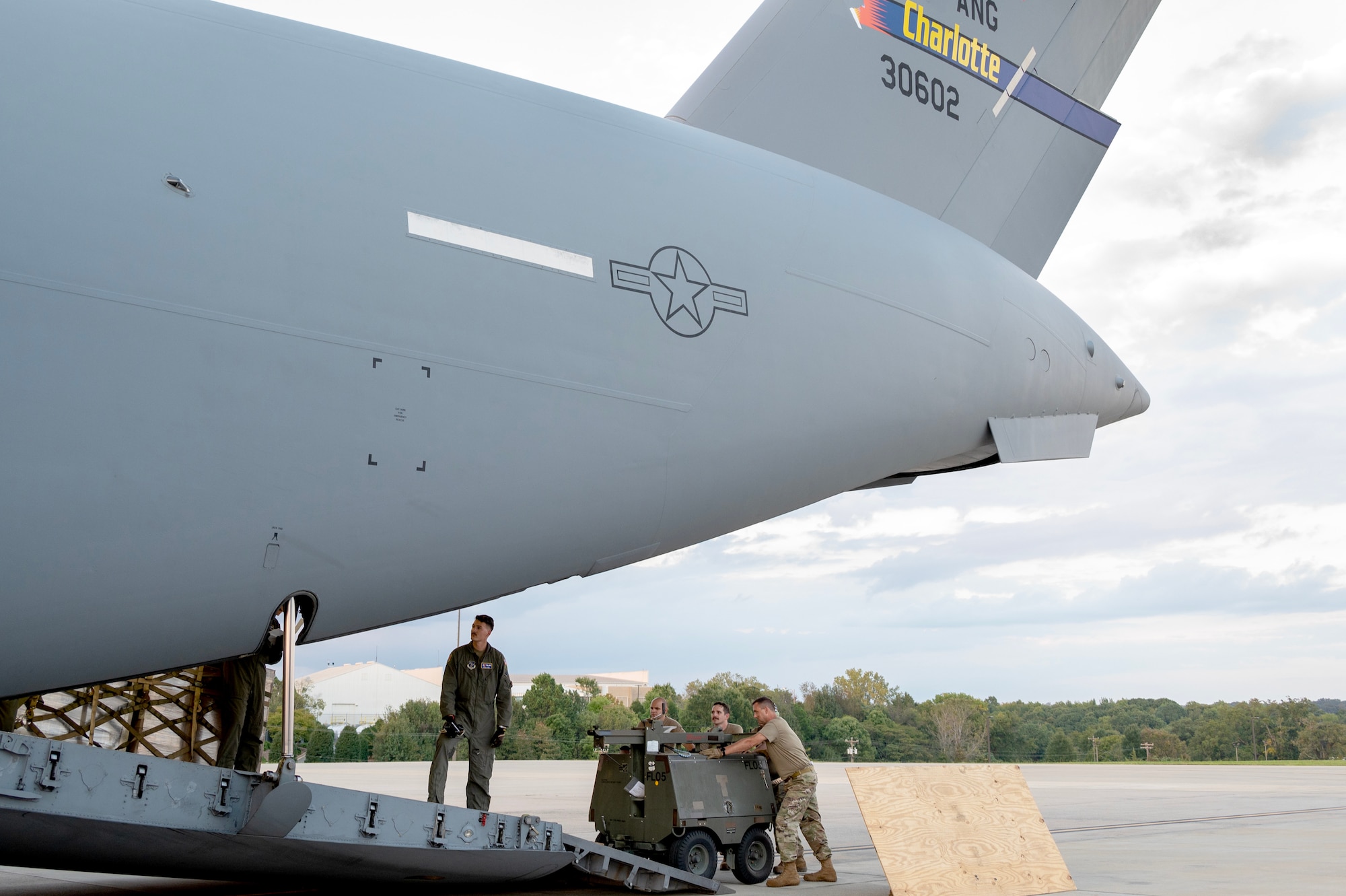 Members of the North Carolina Air National Guard load a light cart onto a C-17 Globemaster III for delivery to Western North Carolina at the North Carolina Air National Guard, Charlotte-Douglas International Airport, October 3, 2024. The cargo delivered aboard the C-17 in support of humanitarian efforts following Tropical Storm Helene consisted of Meals Ready to Eat (MREs), water, medication and other vital supplies. (U.S. Air National Guard photo by Staff Sgt. Reanna Hartgrove)