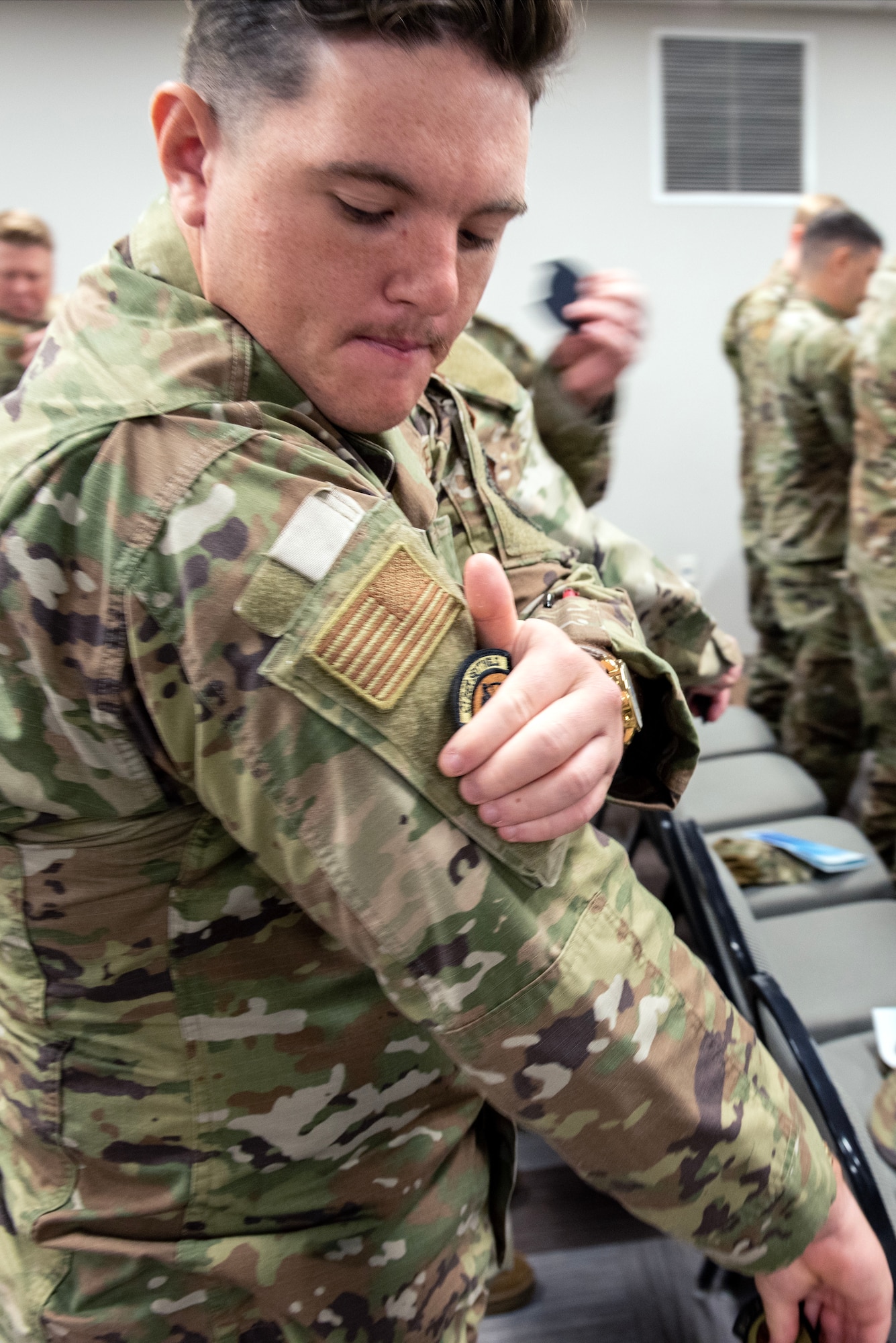 U.S. Airman Chad Haynes, 145th Communications Squadron client systems, places his new squadron patch on his right arm during the redesignation ceremony for the 145th Communications Flight to a squadron in the Epic Center at Charlotte-Douglas International Airport base, Sept. 8, 2024.The 145th Communications Flight was redesignated to a squadron effective Oct. 15, 2023. (U.S. Air National Guard photo by 2nd Lt. Mary McKnight)