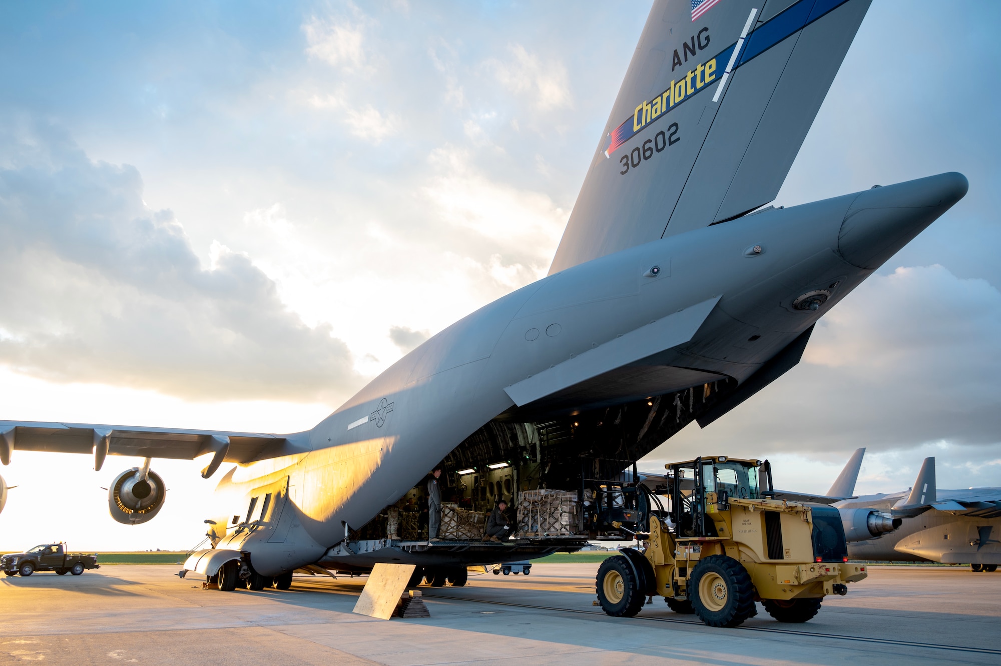 Members of the North Carolina Air National Guard load hurricane relief pallets onto a C-17 Globemaster III  for delivery to Western North Carolina in support of humanitarian efforts following Tropical Storm Helene at the North Carolina Air National Guard, Charlotte-Douglas International Airport, October 3, 2024. The hurricane relief pallets contain Meals ready to Eat (MREs), water, and medication. (U.S. Air National Guard photo by Staff Sgt. Reanna Hartgrove)