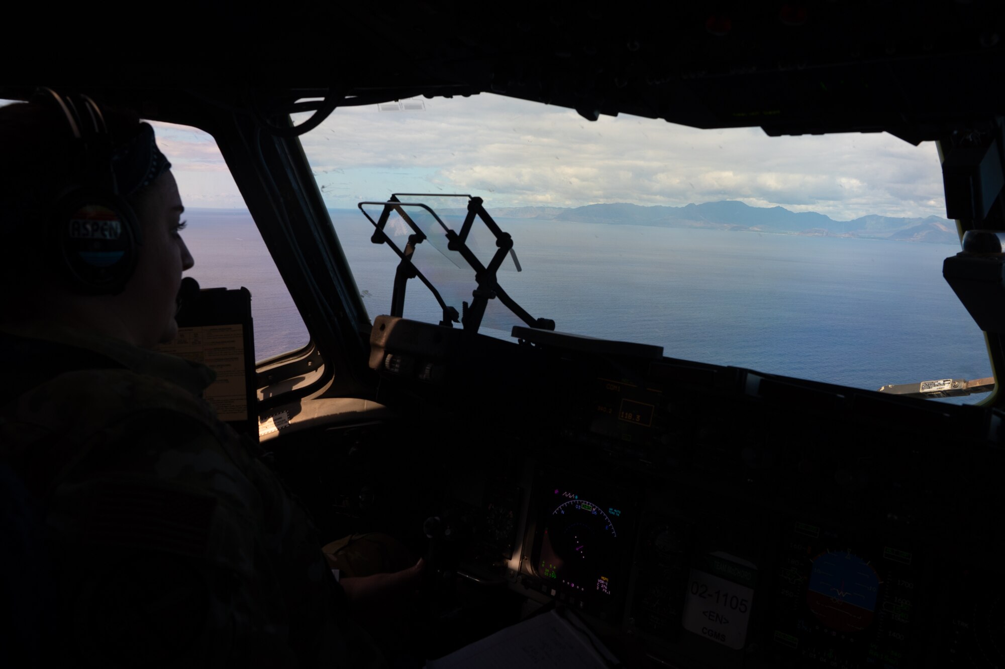 U.S. Air Force Capt. Kourtney Cryder, a pilot from the 7th Airlift Squadron, gazes out the cockpit window as the C-17 approaches Kalaeloa, Hawaii, during Exercise Rainier War 25A on Oct. 4, 2024.