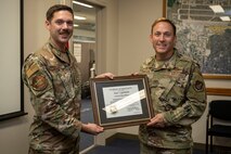 U.S. Air Force Maj. Matthew Bogan, right, 35th Contracting Squadron commander, presents U.S. Air Force Col. Paul Davidson, 35th Fighter Wing commander, a contracting officer certificate of appointment during the end of fiscal year closeout at Misawa Air Base, Japan, Sept. 30, 2024.