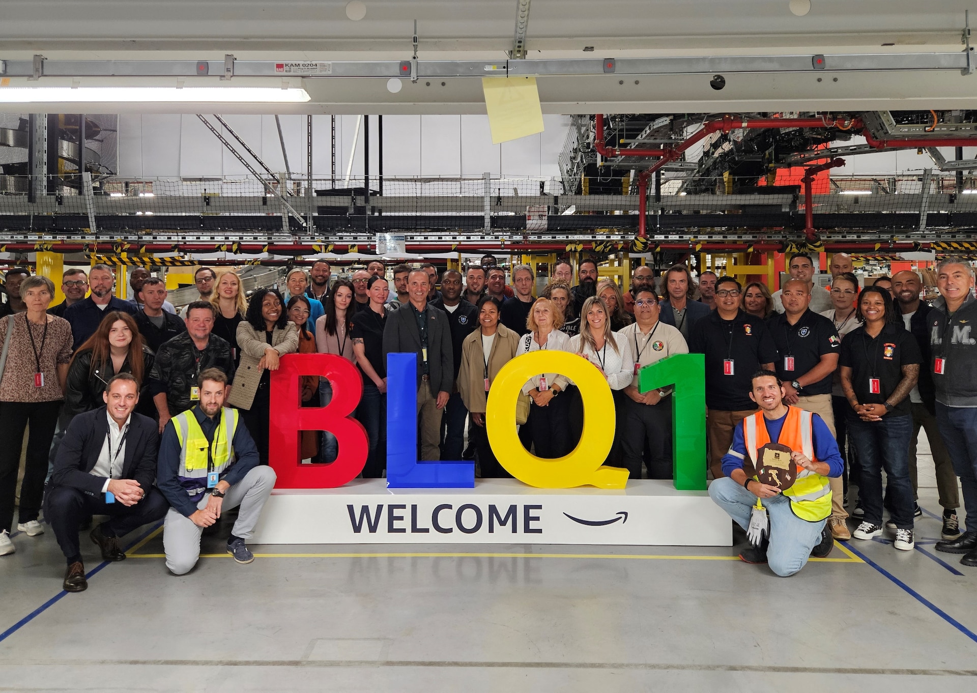 Visiting personnel, to include Logistics Readiness Center Italy and Southern European Task Force-Africa, pose for a photo with some of the staff from the Amazon Fulfillment Center and Delivery Station in Rovigo, Italy, Oct. 2, at the facility. (Elena Esposito)