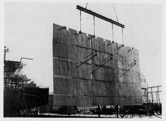 From the December 1, 1967 edition of Service to the Fleet, using a “strong back spreader”, James Creecy, Raymond Griffin, John H. Brinkley, G. Earl Thompson, Wincel E Lawson and Clarence E. Doll guide the 42-ton bulkhead into place. The bulkhead was the first major structural installation and was key to the entire repair sequence.