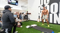 A moment of triumph during Maj. Tommy Vu's world record attempt at a gym in Salem, Ore., Oct. 5, 2024. From left: Pedro Velasquez, Oregon National Guard state equal employment manager; Linda Vu, the major's wife holding son Adonis; and Maj. Tommy Vu as he nears his goal of 1,027 chest-to-ground burpees in one hour.