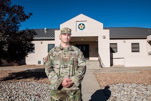 Space Force Guardian poses in uniform in front of the Space RCO office on Kirtland Air Force Base