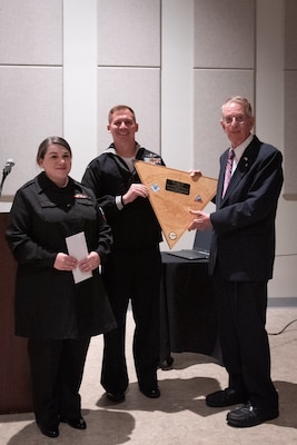 From left to right, Hospital Corpsman Ashlyn Sanders and Hospital Corpsman Kelvin Tseh present a gift to Mr. Wilbur D. Jones. Jr. right, during a Navy Ball hosted by Naval Health Clinic Cherry Point on Friday, October 4, 2024 at the Havelock Convention Center, Havelock North Carolina.

Jones, a nationally recognized historian, was the event’s keynote speaker and spoke about his father who served with the Marines in World War I and the clinic’s namesake and Medal of Honor recipient, Pharmacist’s Mate Second Class William D. Halyburton, Jr.