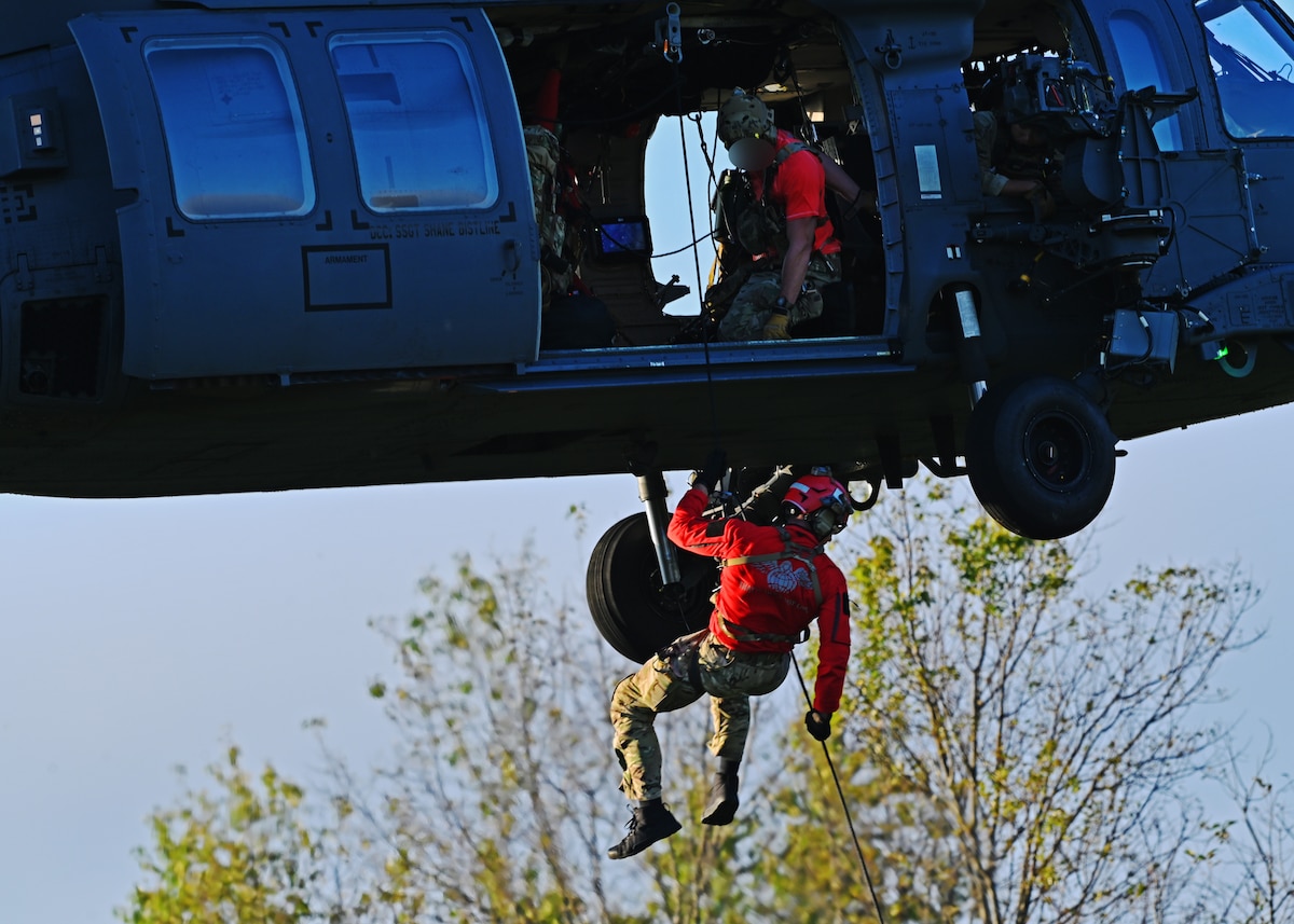 A U.S. Airman assigned to the 48th Rescue Squadron, forward deployed in the 563rd Personnel Recovery Task Force, repels from an HH-60W Jolly Green II helicopter in Tennessee, Oct. 2, 2024, in support of the U.S. Northern Command and Air Forces Northern, Defense Support of Civil Authorities Disaster Relief mission. The Department of Defense has unique capabilities, including an ability to deploy on short notice into austere environments, while providing resources that are not readily available in other federal agencies or the private sector. (U.S. Air Force photo by Staff Sgt. Abbey Rieves) (Note this photo has been altered for security purposes by blurring out facial identification.)