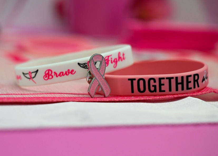 Pink breast cancer awareness bracelets and a ribbon pin are displayed at Wilford Hall's Mammography Clinic, JBSA-Lackland, Texas, on Oct. 3, 2024, as part of National Breast Cancer Awareness Month.