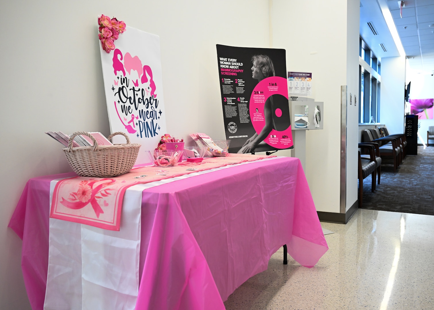 A Breast Cancer Awareness table is set up at Wilford Hall Mammography Clinic, JBSA-Lackland, Texas, on October 3, 2024, with information and pink decor.