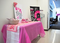 A Breast Cancer Awareness table is set up at Wilford Hall Mammography Clinic, JBSA-Lackland, Texas, on October 3, 2024, with information and pink decor.