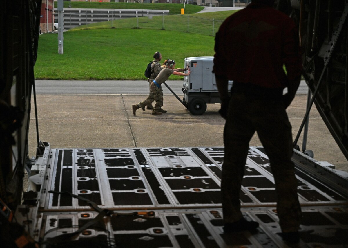 U.S. Airmen assigned to the 79th Rescue Generation Squadron, forward deployed in the 563rd Personnel Recovery Task Force, push a generator for an HC-130J Combat King II aircraft at McGhee Tyson Air National Guard Base, Tennessee, Oct. 3, 2024, in support of the U.S. Northern Command and Air Forces Northern, Defense Support of Civil Authorities Disaster Relief mission. The HC-130J The HC-130J Combat King II aircraft’s mission is to provide aerial refueling capabilities to search and rescue HH-60W Jolly Green II helicopters. (U.S. Air Force photo by Staff Sgt. Abbey Rieves)