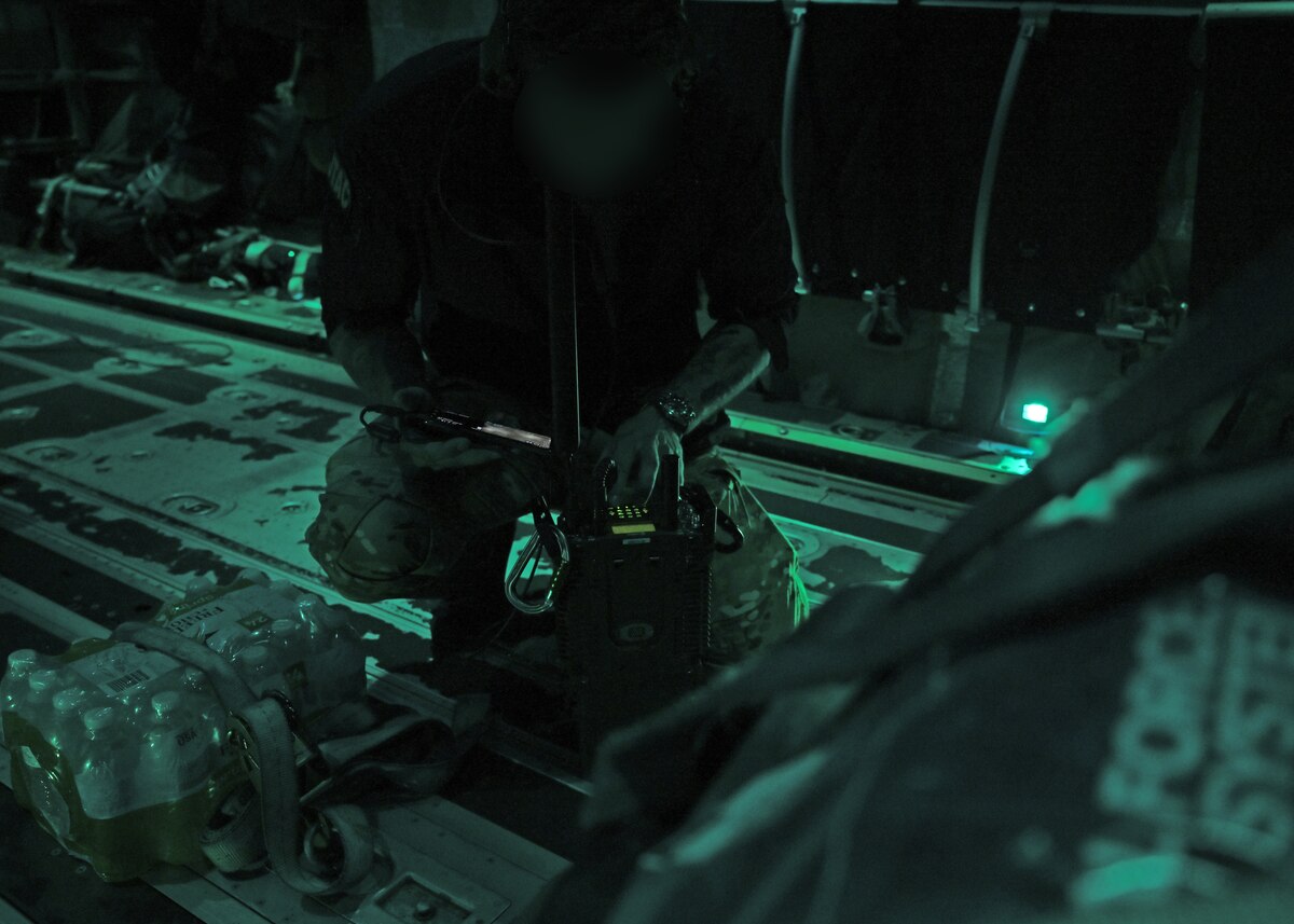 A U.S. Airman from the 48th Rescue Squadron, forward deployed with the 563rd Personnel Recovery Task Force, sets up radio communications with the pararescue team on the ground in Asheville, North Carolina, on Oct. 3, 2024. This operation supports U.S. Northern Command and Air Forces Northern in the Defense Support of Civil Authorities Disaster Relief mission. The 48th RQS and 55th Rescue Squadron have launched ground and air rescue teams to search for and recover residents impacted by Hurricane Helene. (U.S. Air Force photo by Staff Sgt. Abbey Rieves) (Note this photo has been altered for security purposes by blurring out facial identification.)