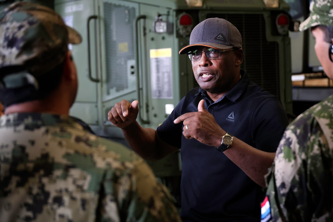 Thurman Bobbett, head of maintenance management branch, Blount Island Command, explains corrective and preventative maintenance procedures for students from Western Hemisphere Institute for Security Cooperation during a tour Sept. 13, 2024, at Marine Corps Support Facility Blount Island in Florida. Of the nearly 60 students from the military education and training institute in Fort Moore, Georgia, roughly half were staff officers from a dozen partner nations spanning from Mexico through South America. After learning about military equipment and staging areas, the students toured USNS 1st Lt. Baldomero Lopez, a U.S. Navy roll-on, roll-off support cargo ship operated by Military Sealift Command. The 1,100-acre Marine Corps facility, located along the St. Johns River in northeast Florida, is the hub of Marine Corps’ prepositioning programs. Blount Island Command personnel—service members, government civilians and federal contractors—ensure Marines responding to global contingency areas are supported with the highest quality combat-ready equipment and supplies.