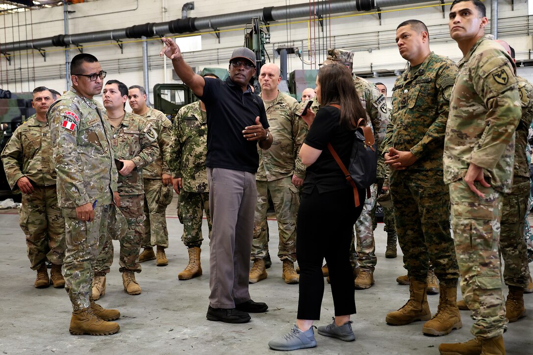 Thurman Bobbett, head of maintenance management branch, Blount Island Command, explains corrective and preventative maintenance procedures for students from Western Hemisphere Institute for Security Cooperation during a tour Sept. 13, 2024, at Marine Corps Support Facility Blount Island in Florida. Of the nearly 60 students from the military education and training institute in Fort Moore, Georgia, roughly half were staff officers from a dozen partner nations spanning from Mexico through South America. After learning about military equipment and staging areas, the students toured USNS 1st Lt. Baldomero Lopez, a U.S. Navy roll-on, roll-off support cargo ship operated by Military Sealift Command. The 1,100-acre Marine Corps facility, located along the St. Johns River in northeast Florida, is the hub of Marine Corps’ prepositioning programs. Blount Island Command personnel—service members, government civilians and federal contractors—ensure Marines responding to global contingency areas are supported with the highest quality combat-ready equipment and supplies.