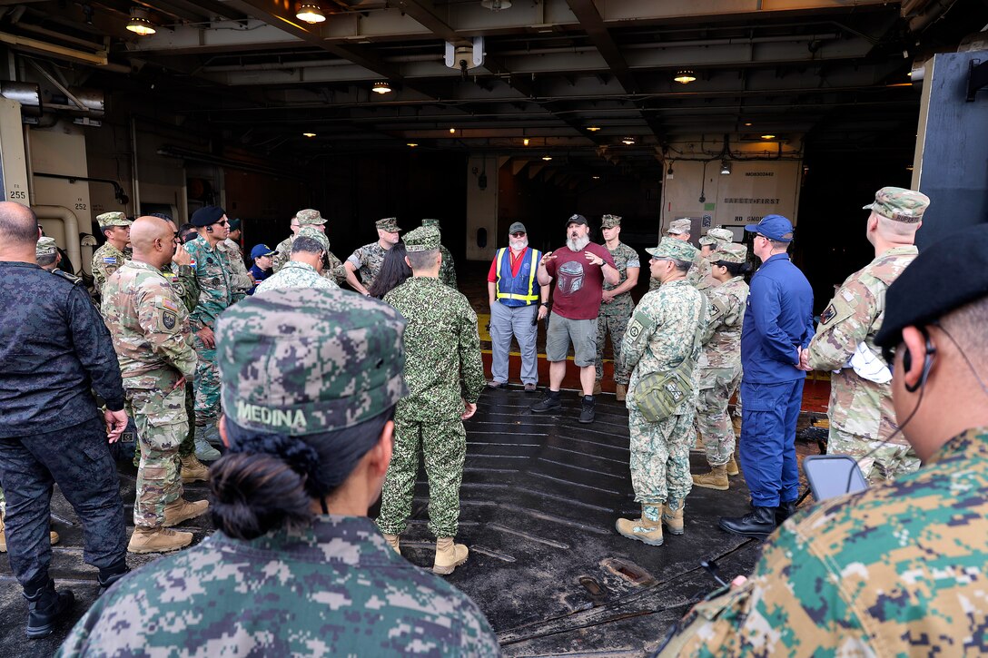 Jacob George, chief mate, Crowley Government Solutions, explains cargo and crew operations on the USNS 1st Lt. Baldomero Lopez for students from Western Hemisphere Institute for Security Cooperation during a tour Sept. 13, 2024, at Marine Corps Support Facility Blount Island in Florida. Of the nearly 60 students from the military education and training institute in Fort Moore, Georgia, roughly half were staff officers from a dozen partner nations spanning from Mexico through South America. After learning about military equipment and staging areas, the students toured USNS Lopez, a U.S. Navy roll-on, roll-off support cargo ship operated by Military Sealift Command. The 1,100-acre Marine Corps facility, located along the St. Johns River in northeast Florida, is the hub of Marine Corps’ prepositioning programs. Blount Island Command personnel—service members, government civilians and federal contractors—ensure Marines responding to global contingency areas are supported with the highest quality combat-ready equipment and supplies.
