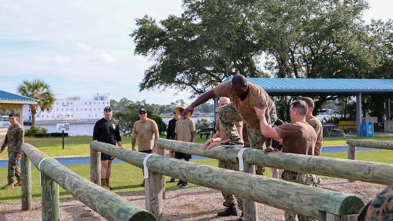Petty Officer First Class Alexander Boston of Bartow, Florida, assigned to the U.S. Navy destroyer USS Carney, homeported at Naval Station Mayport in Jacksonville, traverses an obstacle course while completing chief petty officer initiation capstone events Sept. 25 at Marine Corps Support Facility Blount Island in Florida.