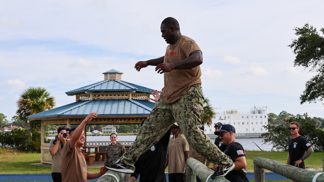 Petty Officer First Class Alexander Boston of Bartow, Florida, assigned to the U.S. Navy destroyer USS Carney, homeported at Naval Station Mayport in Jacksonville, traverses an obstacle course while completing chief petty officer initiation capstone events Sept. 25 at Marine Corps Support Facility Blount Island in Florida.