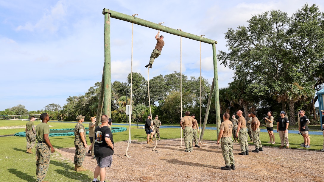 Marines assist Sailors assigned to the U.S. Navy destroyer USS Carney, homeported at Naval Station Mayport in Jacksonville, with traversing an obstacle course while completing chief petty officer initiation capstone events Sept. 25 at Marine Corps Support Facility Blount Island in Florida.