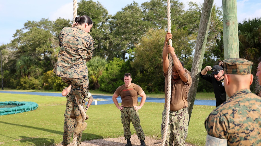 Marines assist Sailors assigned to the U.S. Navy destroyer USS Carney, homeported at Naval Station Mayport in Jacksonville, with traversing an obstacle course while completing chief petty officer initiation capstone events Sept. 25 at Marine Corps Support Facility Blount Island in Florida.