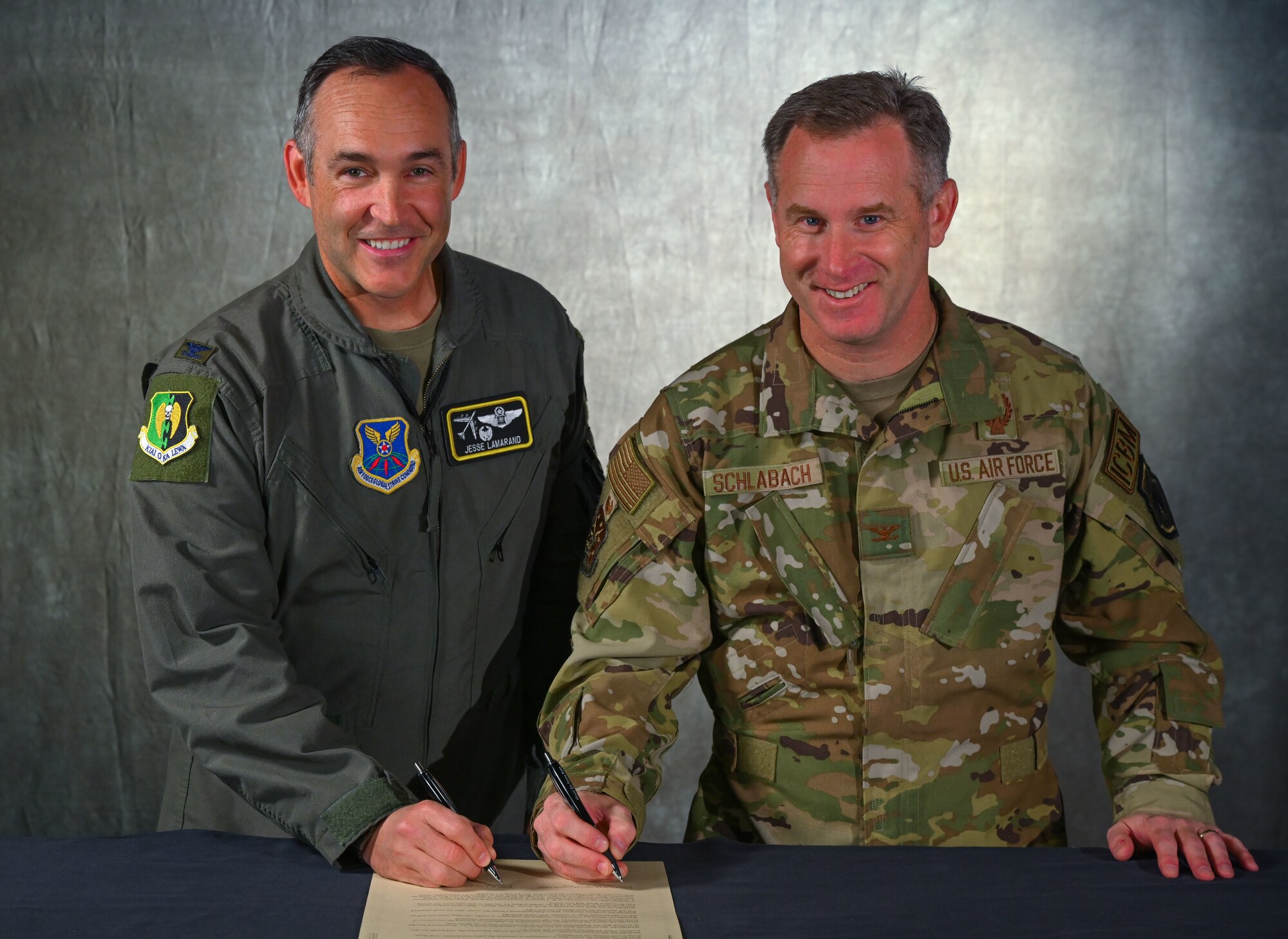 U.S. Air Force Col. Jesse Lamarand, 5th Bomb Wing (5 BW) commander (left), and Col. James Schlabach, 91st Missile Wing (91 MW) commander (right), sign the 5BW and 91MW Fire Prevention Week (FPW) Proclamation on Sept. 30, 2024, Minot Air Force Base, North Dakota. FPW is a time focused on raising public awareness about fire safety.