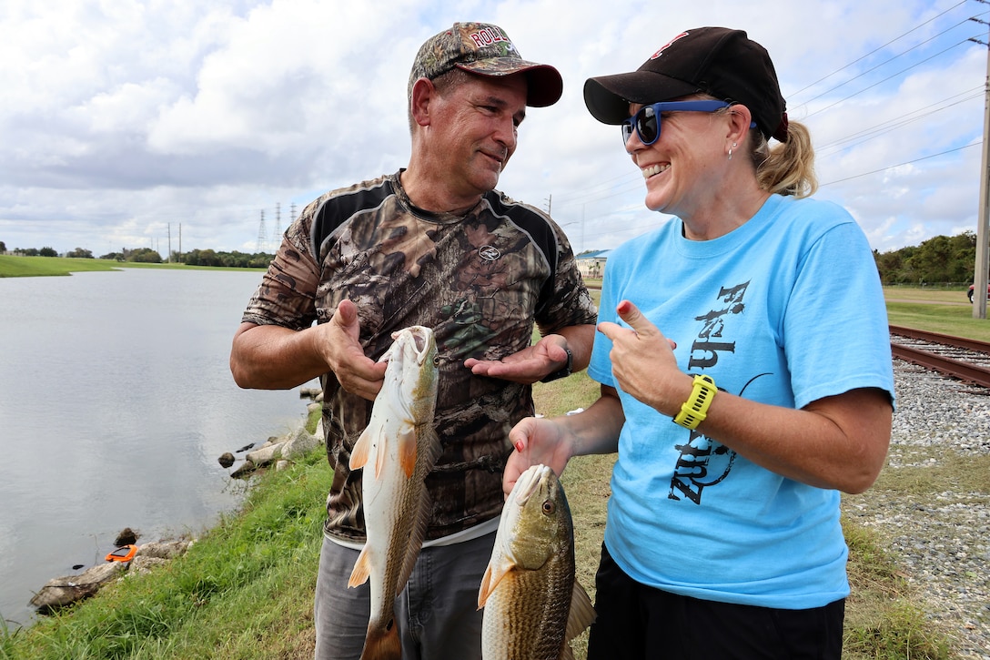 Bobby Carter, Blount Island Command engineer equipment manager, compares redfish catches with wife Frances Carter, financial manager, during a quarterly catch-and-release tournament Oct. 3, 2024, at Marine Corps Support Facility Blount Island in Florida.