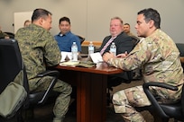16th Air Force Airmen and Philippine Army talk to each other in a conference room.