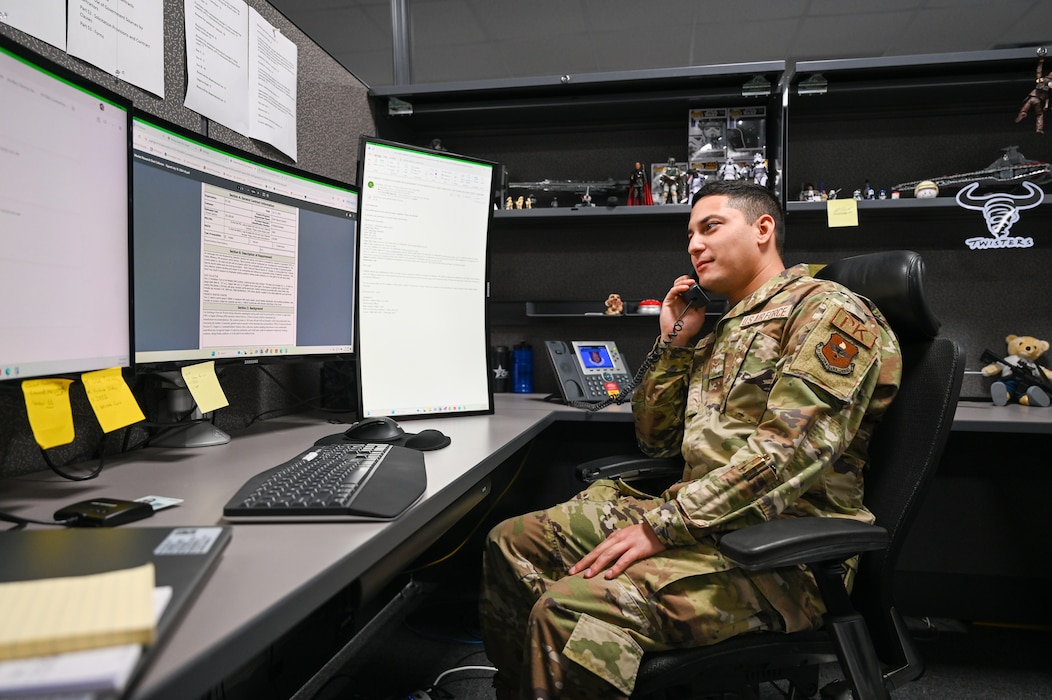 U.S. Air Force Airman 1st Class Andres Lugo, 97th Contracting Flight contracting specialist, talks on the phone at his desk at Altus Air Force Base (AFB), Oklahoma, Sept. 23, 2024. As a contracting specialist, Lugo prepares and handles contracts to buy products and services at Altus AFB and Ebbing Air National Guard Base, Fort Smith, Arkansas. (U.S. Air Force photo by Senior Airman Kari Degraffenreed)