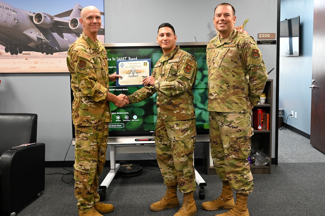 U.S. Air Force Airman 1st Class Andres Lugo, 97th Contracting Flight contracting specialist, is awarded August Airmen of the Month by Col. Jeff Marshall, 97th Air Mobility Wing (AMW) commander, and Chief Master Sgt. Justin Brundage, 97th AMW command chief, at Altus Air Force Base, Oklahoma, Sept. 23, 2024.