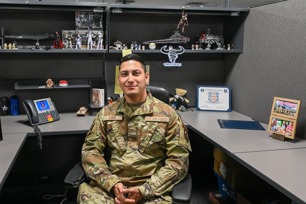 U.S. Air Force Airman 1st Class Andres Lugo, 97th Contracting Flight contracting specialist, sits at his desk for a photo.