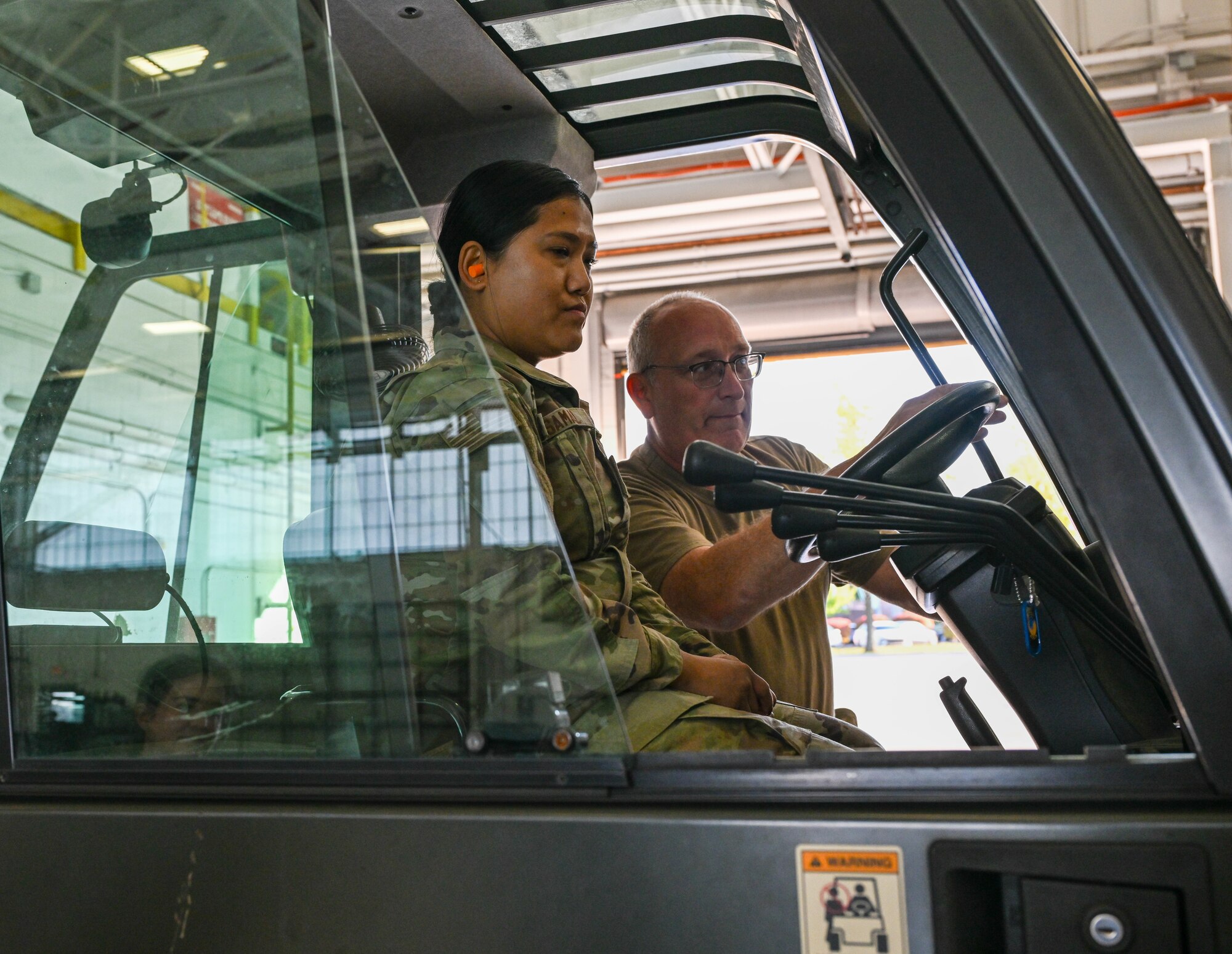 Senior Airman Ashmita Samal (left), a passenger operations representative, and Tech. Sgt. Keith Lenkner (right), a ramp operations representative, both with the 76th Aerial Port Squadron, discuss how to keep forkers even with the rollers during a training exercise at Youngstown Air Reserve Station, Ohio, Oct. 6, 2024.