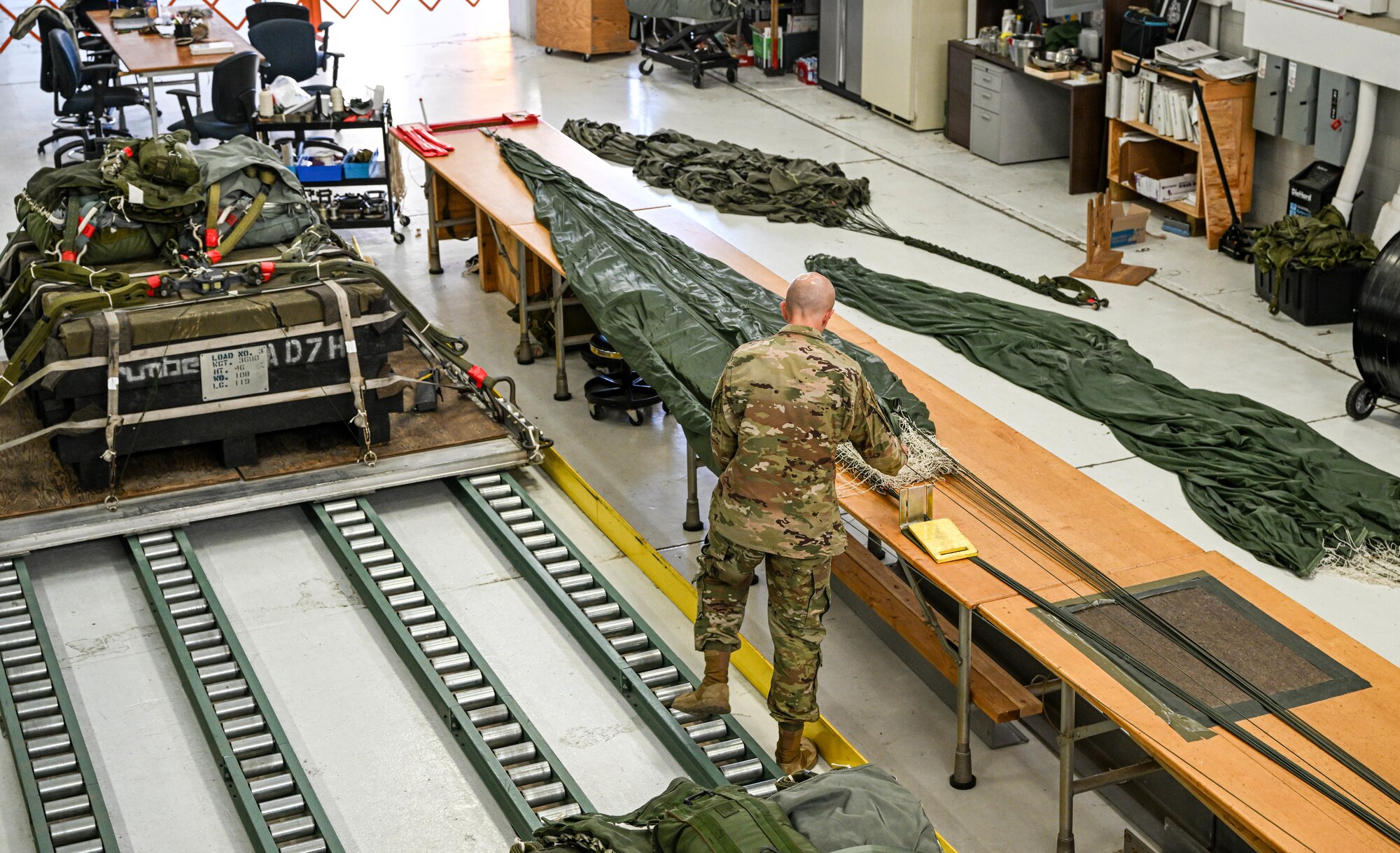 Master Sgt. Ryan Rathburn, a cargo processing representative with the 76th Aerial Port Squadron, prepares a parachute using line separation during a training exercise, at Youngstown Air Reserve Station, Ohio, Oct. 6, 2024.