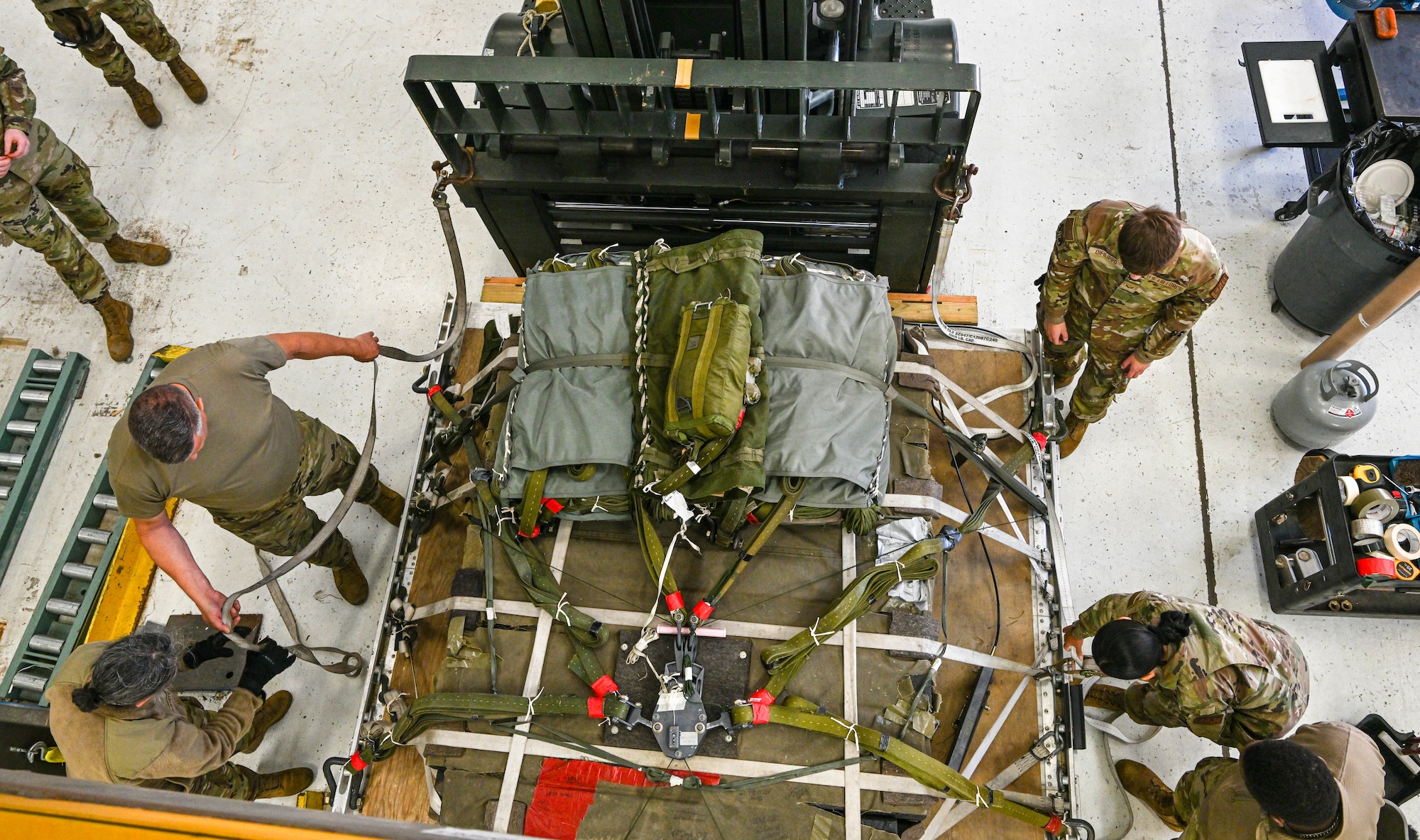 Members of the 76th Aerial Port Squadron secure a heavy drop load pallet to a forklift mast during a training exercise, at Youngstown Air Reserve Station, Ohio, Oct. 6, 2024.