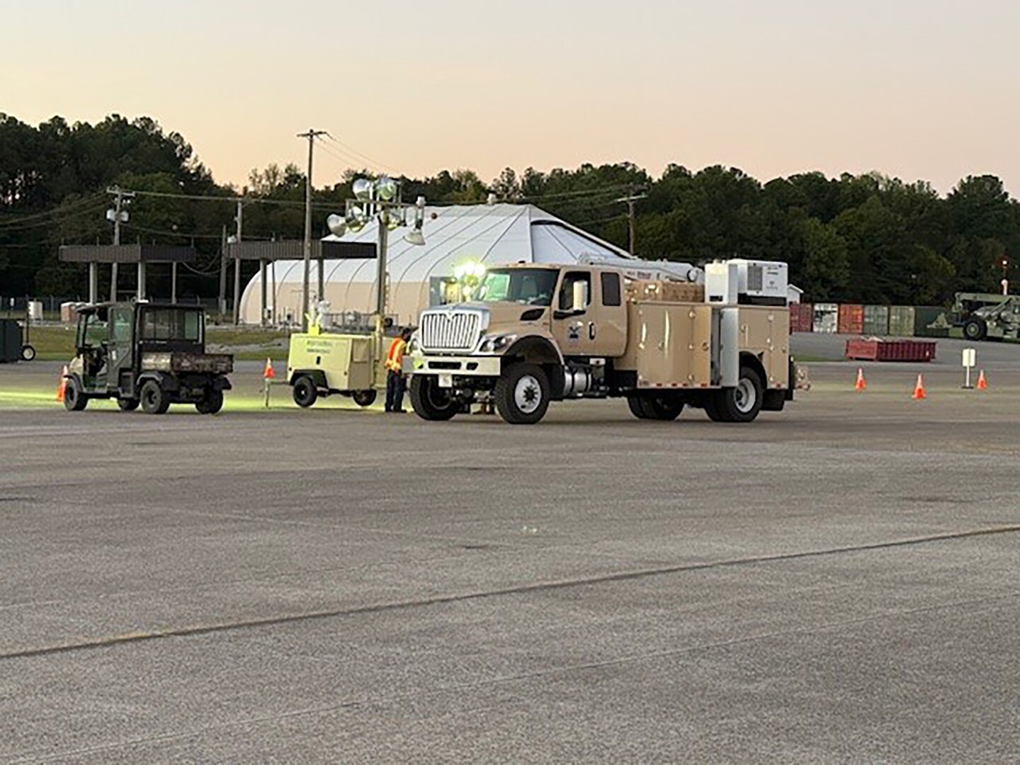 Trucks set up lighting in a parking lot