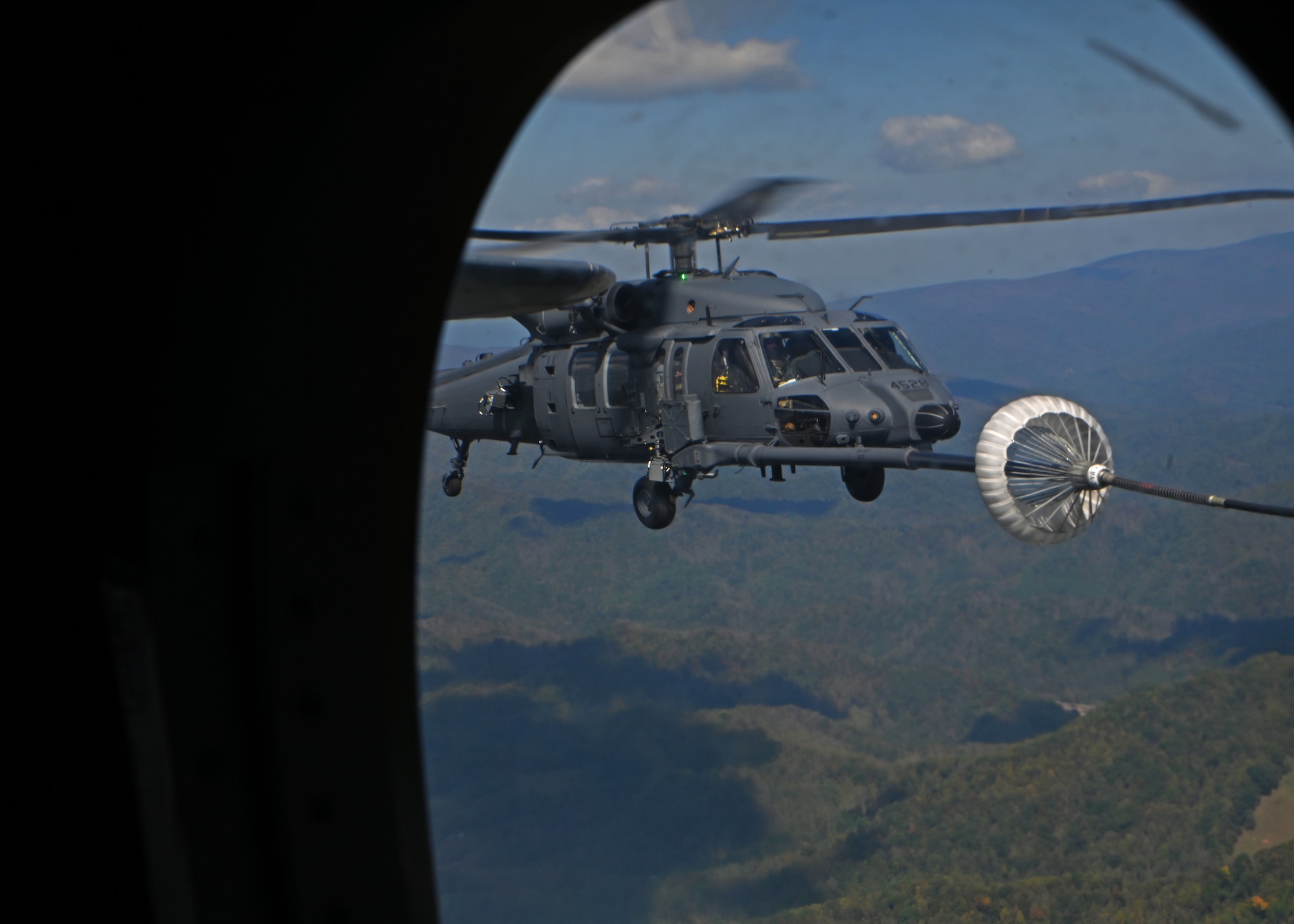 An HH-60W Jolly Green II helicopter, assigned to the 55th Rescue Squadron, forward deployed as the 563rd Personnel Recovery Task Force, conducts helicopter air-to-air refueling in North Carolina, Oct. 6, 2024, in support of the U.S. Northern Command and Air Forces Northern, Defense Support of Civil Authorities Disaster Relief mission. The 55th RQS conducts military operations that include civil search and rescue, disaster relief, international aid, emergency medical evacuation and counter-drug activities. (U.S. Air Force photo by Staff Sgt. Abbey Rieves)