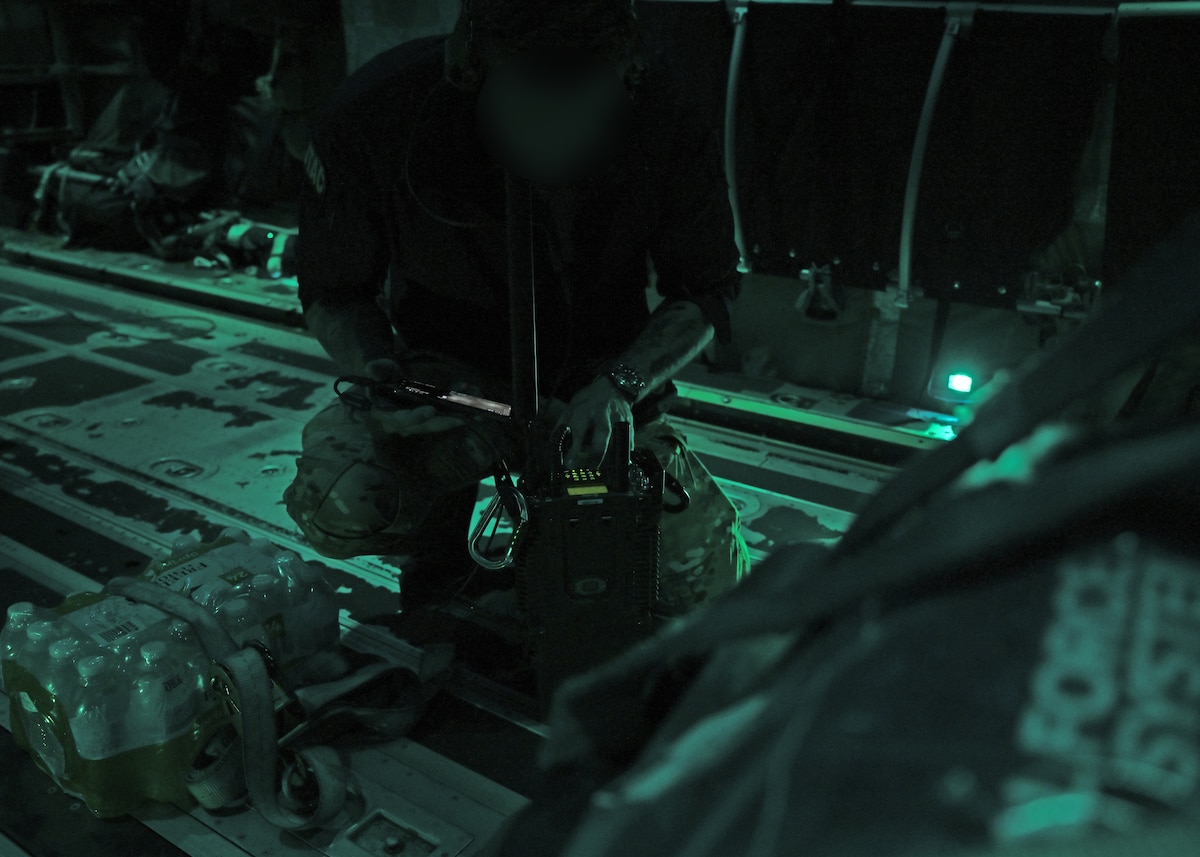 A U.S. Airman from the 48th Rescue Squadron, forward deployed with the 563rd Personnel Recovery Task Force, sets up radio communications with the pararescue team on the ground in Asheville, North Carolina, on Oct. 3, 2024. This operation supports U.S. Northern Command and Air Forces Northern in the Defense Support of Civil Authorities Disaster Relief mission. The 48th RQS and 55th Rescue Squadron have launched ground and air rescue teams to search for and recover residents impacted by Hurricane Helene. (U.S. Air Force photo by Staff Sgt. Abbey Rieves) (Note this photo has been altered for security purposes by blurring out facial identification.)