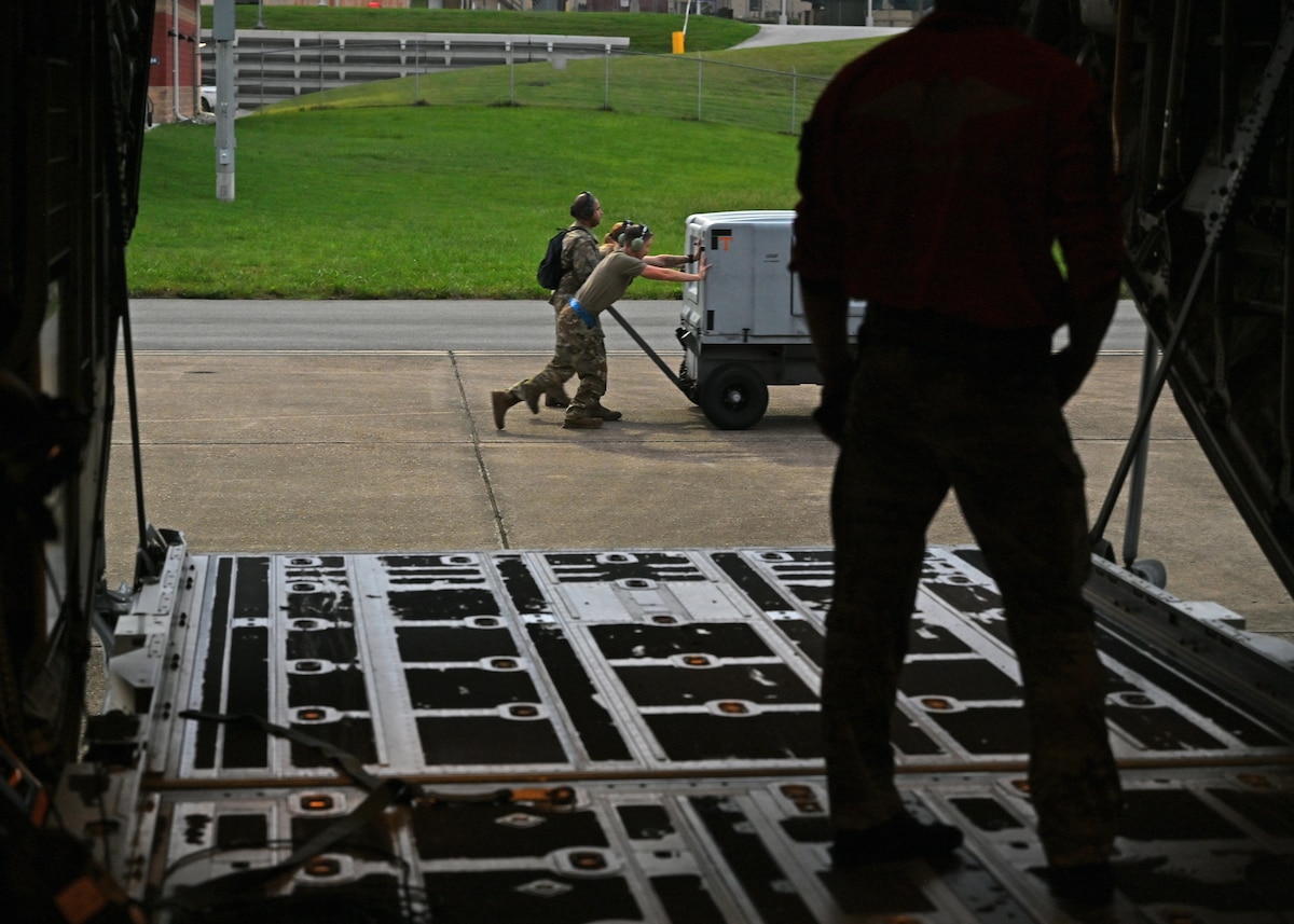 U.S. Airmen assigned to the 79th Rescue Generation Squadron, forward deployed in the 563rd Personnel Recovery Task Force, push a generator for an HC-130J Combat King II aircraft at McGhee Tyson Air National Guard Base, Tennessee, Oct. 3, 2024, in support of the U.S. Northern Command and Air Forces Northern, Defense Support of Civil Authorities Disaster Relief mission. The HC-130J The HC-130J Combat King II aircraft’s mission is to provide aerial refueling capabilities to search and rescue HH-60W Jolly Green II helicopters. (U.S. Air Force photo by Staff Sgt. Abbey Rieves)