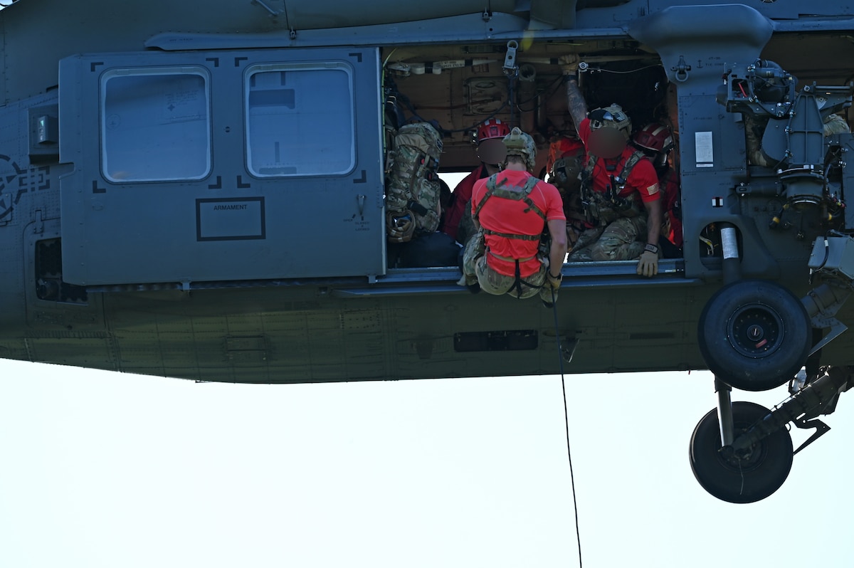 A U.S. Airman assigned to the 48th Rescue Squadron, forward deployed as the 563rd Personnel Recovery Task Force, repels in Tennessee, Oct. 2, 2024, in support of the U.S. Northern Command and Air Forces Northern, Defense Support of Civil Authorities Disaster Relief mission. The Department of Defense’s collaborative, whole-of-government response efforts with interagency partners demonstrate our national capabilities and resilience in recovering from disasters. (U.S. Air Force photo by Staff Sgt. Abbey Rieves) (Note this photo has been altered for security purposes by blurring out facial identification.)