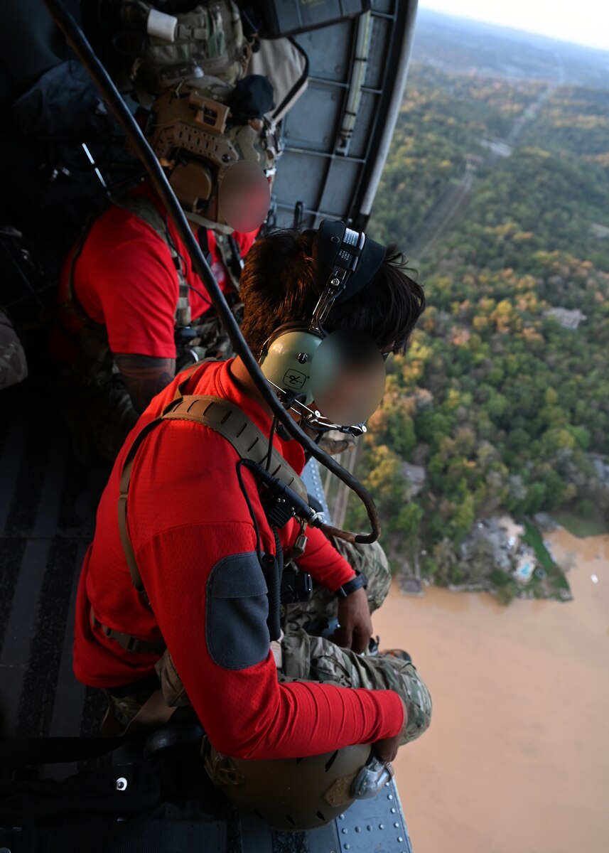 U.S. Airmen assigned to the 48th Rescue Squadron, forward deployed in the 563rd Personnel Recovery Task Force, rehearse aerial scanning techniques aboard an HH-60 Jolly Green II helicopter in Tennessee, Oct. 2, 2024, in support of the U.S. Northern Command and Air Forces Northern, Defense Support of Civil Authorities Disaster Relief mission. The Department of Defense has unique capabilities, including an ability to deploy on short notice into austere environments, while providing resources that are not readily available in other federal agencies or the private sector. (U.S. Air Force photo by Staff Sgt. Abbey Rieves) (Note this photo has been altered for security purposes by blurring out facial identification.)