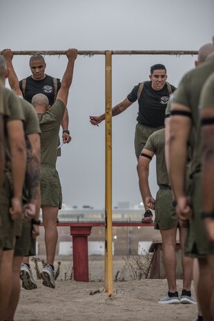 U.S. Marine Corps Gunnery Sgt. Dana Jackson, left, and Staff Sgt. Alexander Cevalles, right, instructors with Marine Corps Recruit Depot San Diego Drill Instructor School, Recruit Training Regiment, supervise the pull-up portion of the physical fitness test at Marine Corps Recruit Depot San Diego, California, Oct. 4, 2024. DI School develops leadership, command presence, instructional ability, physical fitness, and professional knowledge in officers, staff noncommissioned and noncommissioned officers to prepare them for the duties of a drill instructor. (U.S. Marine Corps photo by Cpl. Alexandra M. Earl)