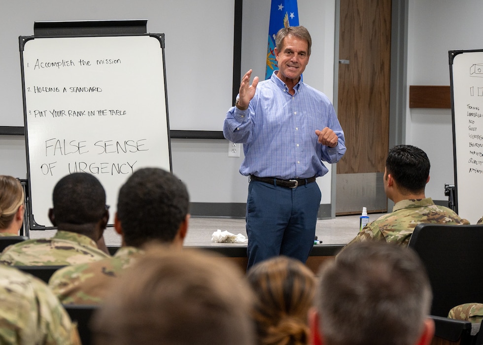 man speaks to group in auditorium