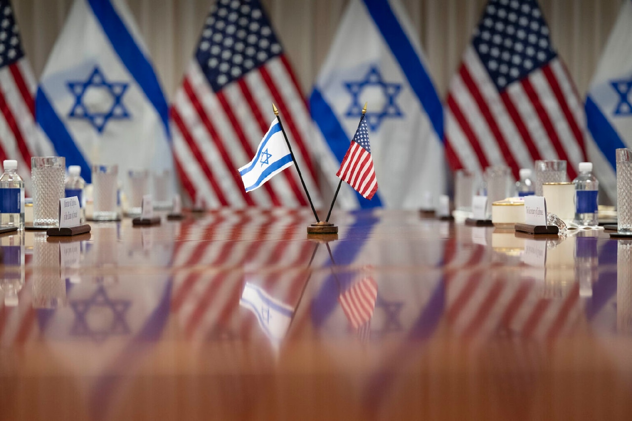 U.S. and Israeli flags are displayed on a table.