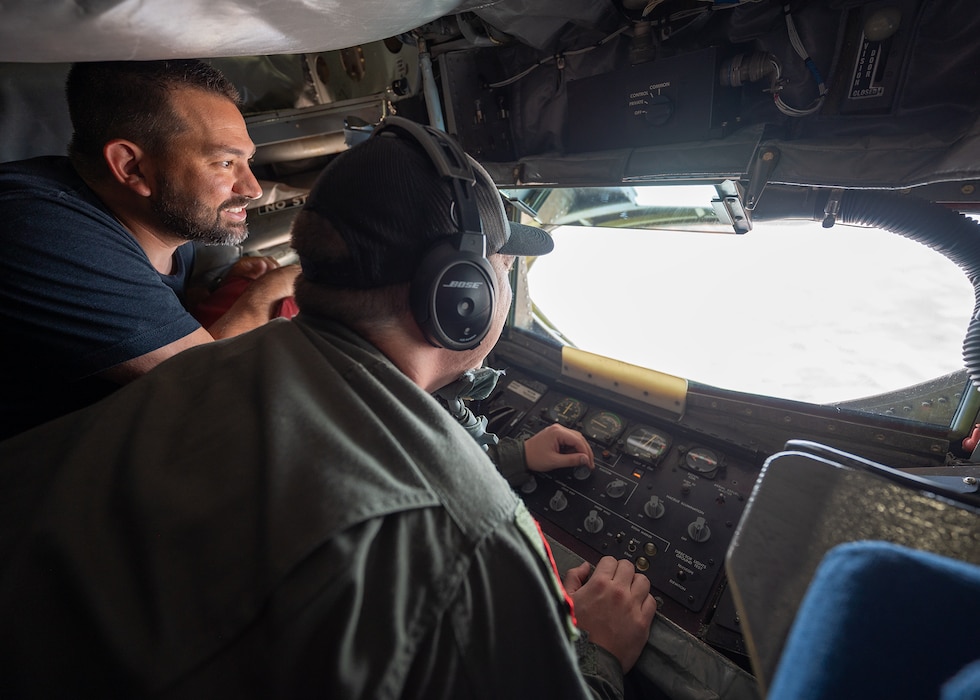 men look out of window of KC-135 boom pod