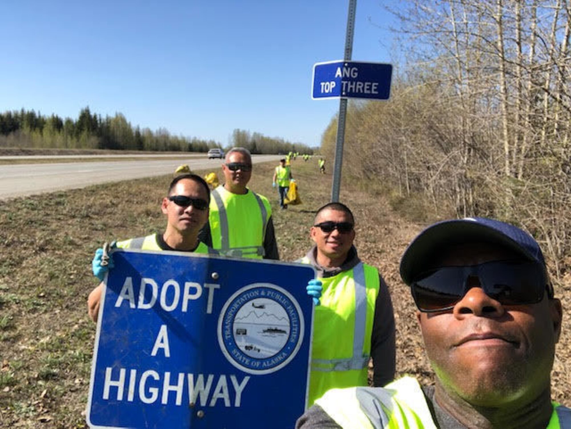 Senior Master Sgt. Ruperto Perez III, Master Sgt. Albert Atoigue, Master Sgt. Shane Jenkins, Master Sgt. RJ Cardines and Senior Airman Kyle Wilson (in the background) of the 168th Wing take a photo op during the Top 3 Highway Clean-up of Mile marker 353 to 354 between North Pole and Fairbanks, Alaska.