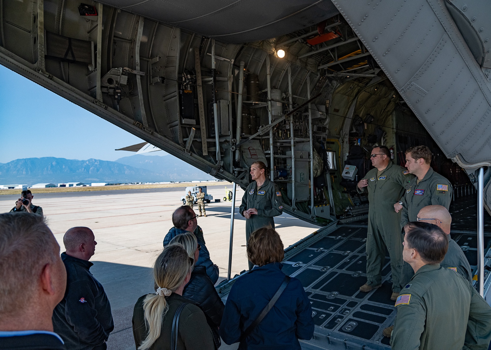 A group of people standing at the back of an aircraft.