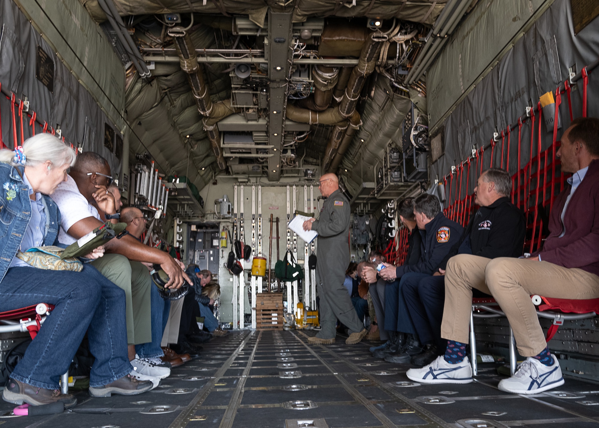 A group of people aboard the back of an aircraft.