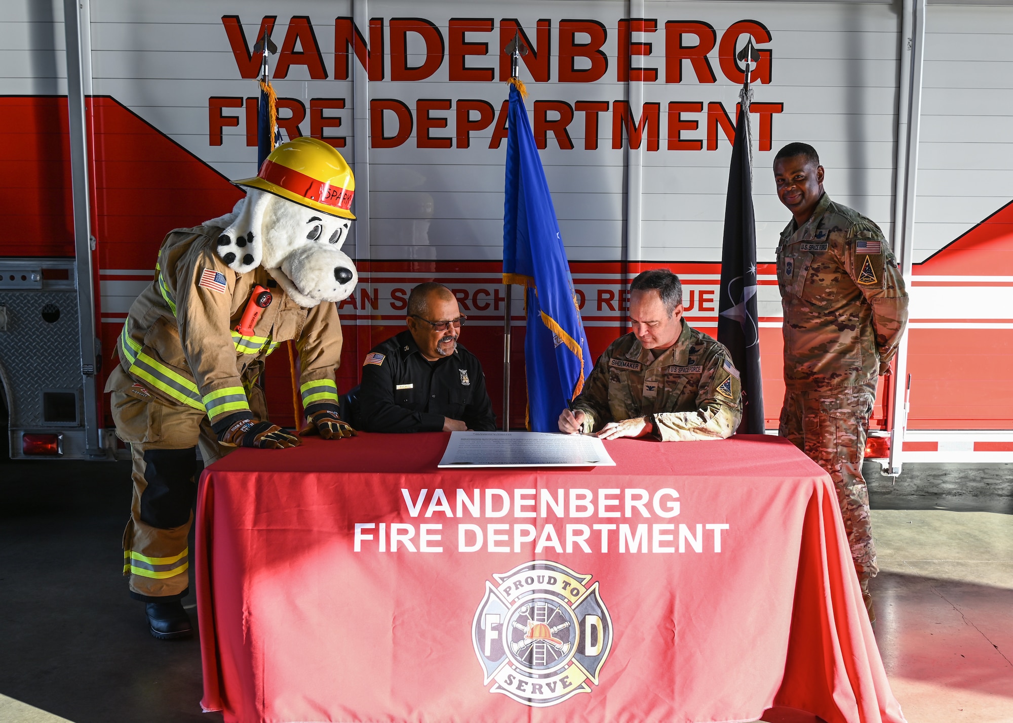 A Space Launch Delta 30 commander (center right), and a 30th Civil Engineer Squadron fire chief (center left), sign a Fire Prevention Week proclamation at Vandenberg Space Force Base.