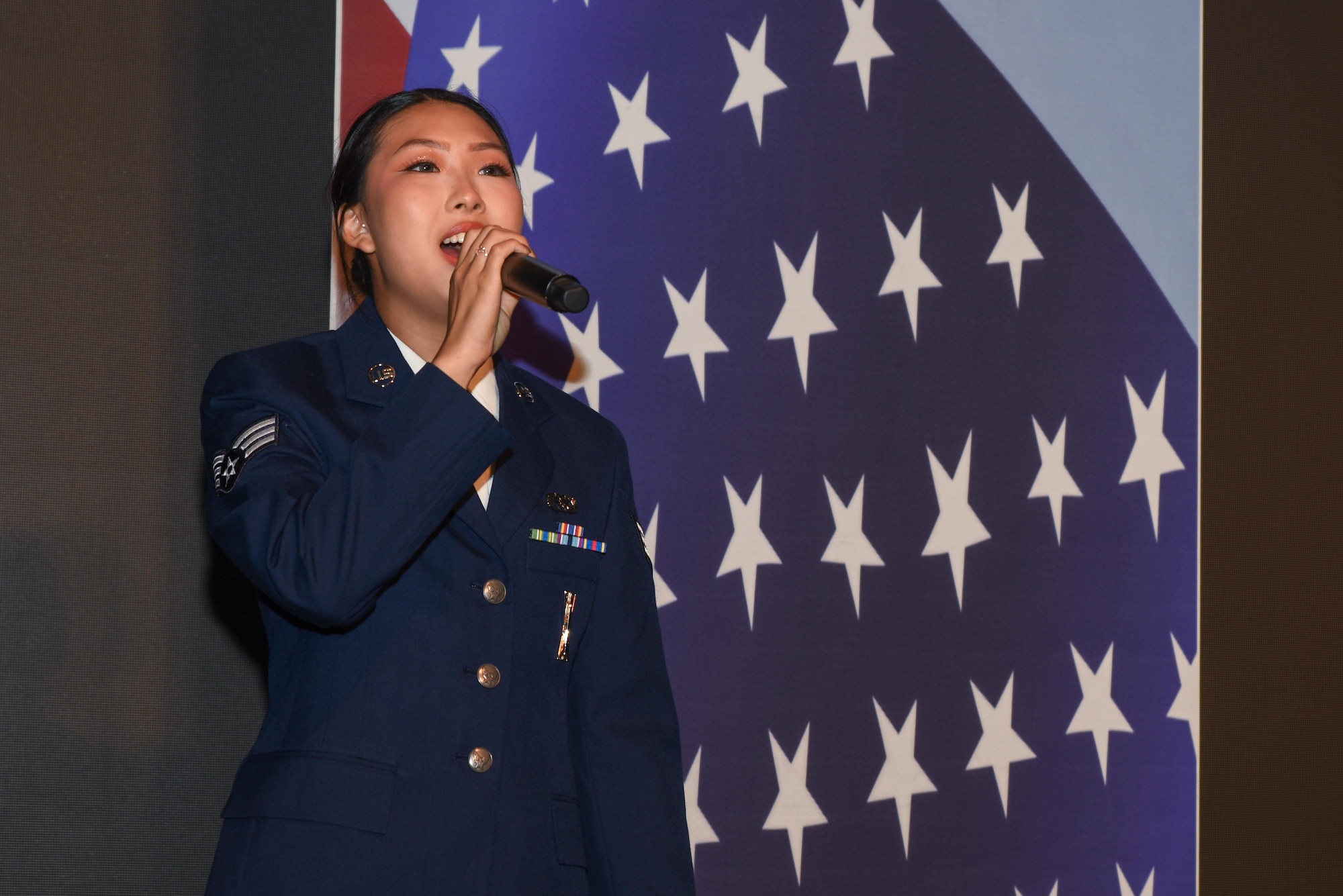 U.S. Air Force Senior Airman Hannah Noh, 51st Maintenance Group squadron lead crew member, sings the Korean and U.S. national anthems during the 7th Air Force’s Peninsula Wide AF Ball, Oct 4, 2024, at the Grand Walkerhill Hotel in Seoul, Republic of Korea. Formal events on the Korean peninsula traditionally include the national anthems of both nations, showing respect to the longstanding partnership between the two countries. (U.S. Air Force photo by Staff Sgt. Kahdija Slaughter)