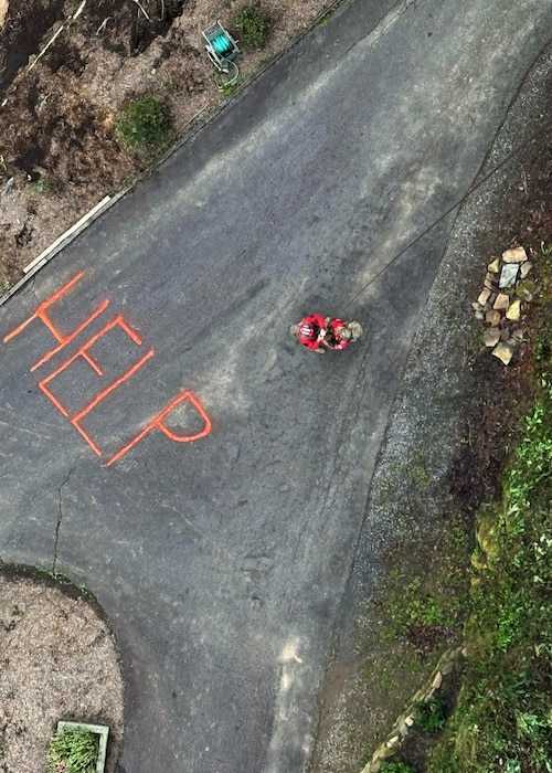 Two U.S. pararescuemen assigned to the 48th Rescue Squadron, forward deployed as the 563rd Personnel Recovery Task Force, repel from an HH-60W Jolly Green II helicopter in North Carolina, Oct. 4, 2024, in support of the U.S. Northern Command and Air Forces Northern, Defense Support of Civil Authorities Disaster Relief mission. The aerial rescue team saw the word “HELP” written on a driveway and responded. (Courtesy photo)