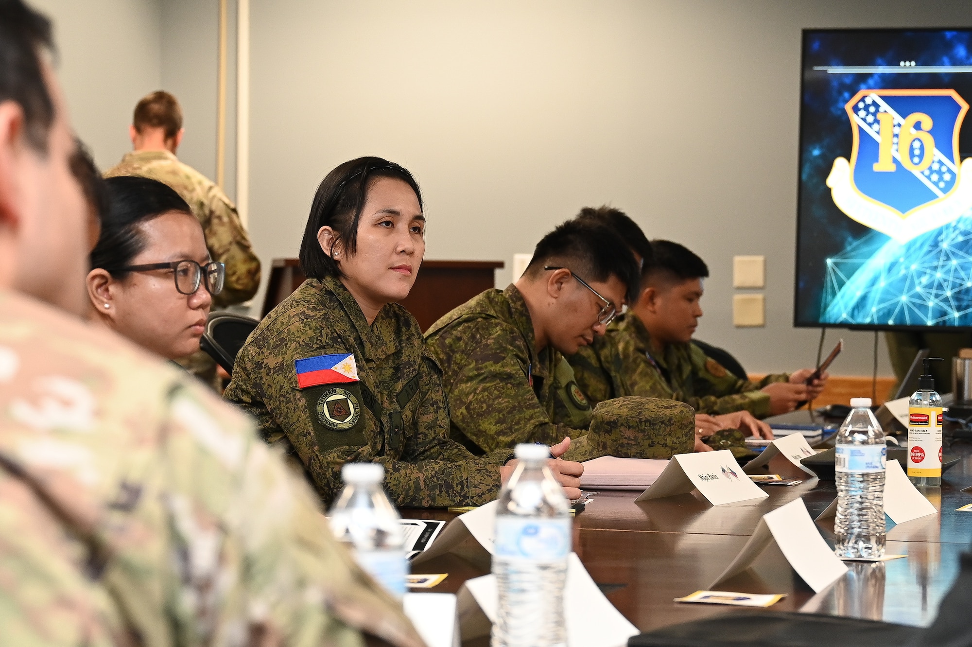 16th Air Force Airmen and Philippine Army talk to each other in a conference room.